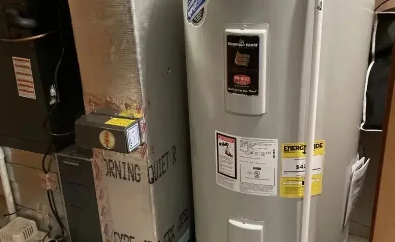 Residential water heater installed beside HVAC system in a home utility room